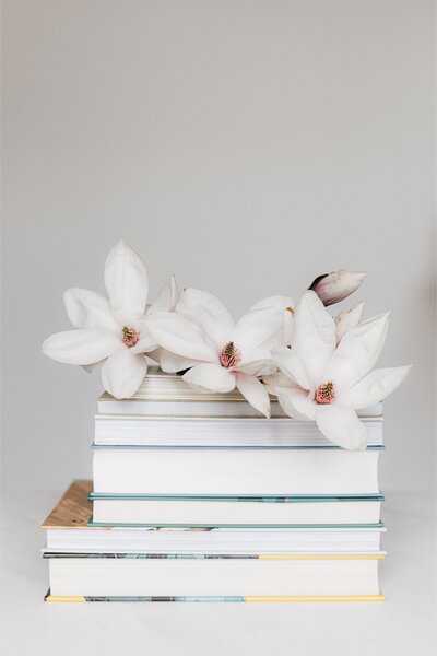flowers on top of books on a white background