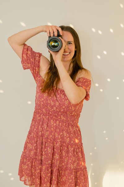 photographer holding camera looking at camera smiling