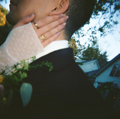 film photo of bride rests hand on groom's neck