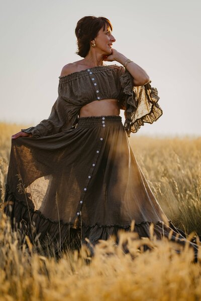 mom standing in a Saskatchewan wheat field in a beautiful two piece dress during an empowerment photo session 