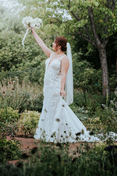 bride holding bridal bouquet up in air