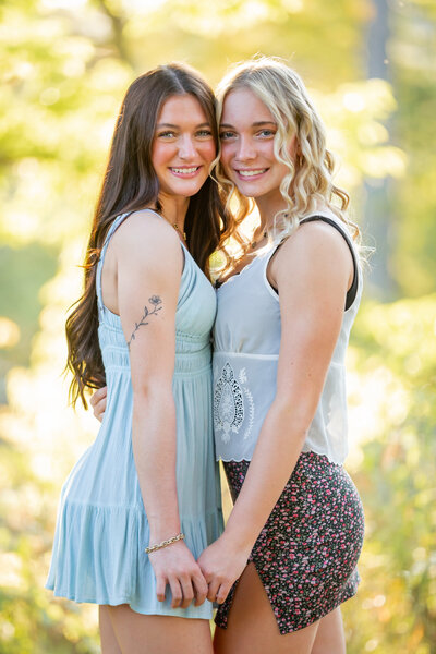 Two Harrison High School senior girls pose facing each other at Dow Gardens in Midland Michigan. Photos taken by Megan Jones Photography