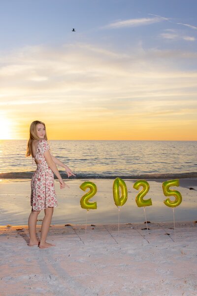 Senior girl on the beach with 2025 balloons