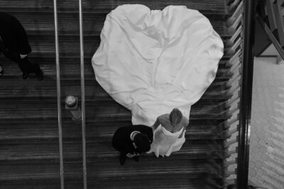 Black and white image of couple walking down stairs together
