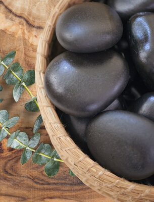 Hot massage stones in a woven basket