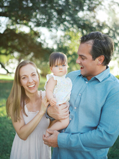 Mother looking at camera during casual barefoot newborn session.