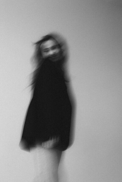 Blurry image of a woman wearing a black top
