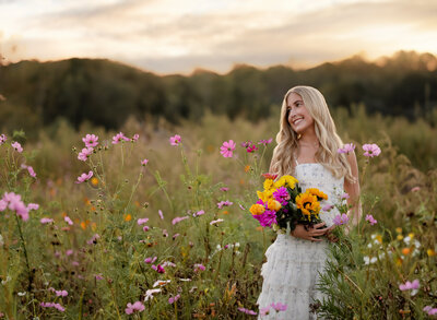 Graduation photo of girl in sundress in a field of wildflowers near Atlanta, GA. Photo taken by Jenni Nikki Photography at West Milford Farms in Ballground, GA.