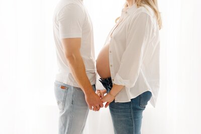 expecting parents holding hands taken by boston maternity photographer