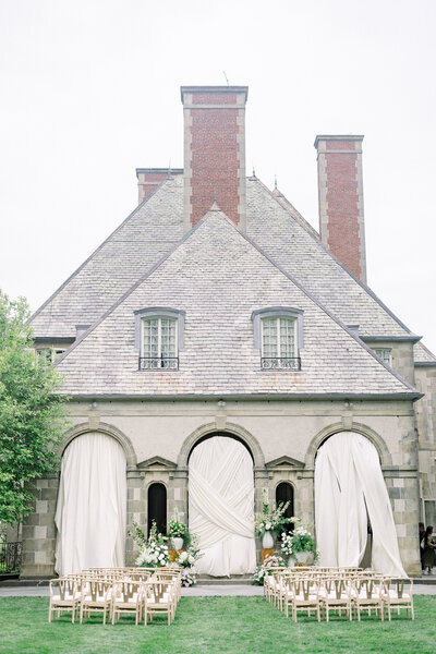 white drapery and lush florals at a wedding ceremony on lawn of glen manor in Newport county, Rhode island