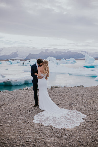 Iceland Wedding photographer captures outdoor elopement of bride and groom kissing at waterfall