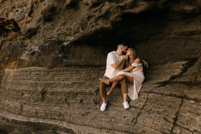 Couple in white embracing on beach