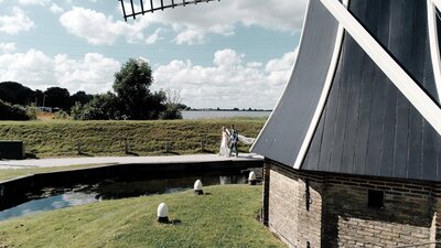 Bruidspaar loopt hand in hand voor Kasteel haar gefilmd met een drone. 
