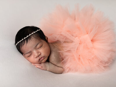 newborn baby girl in pink tutu posed for studio portraits