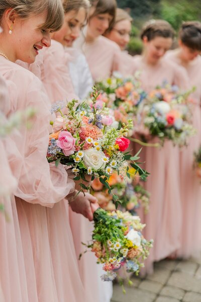 Spring wedding at the glover mansion with bridesmaids holding colorful bouquets of spring flowers and in pink tulle bridesmaid dresses