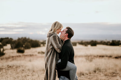 Bride jumping over a puddle of water during their engagement session in Old Town, Albuquerque.