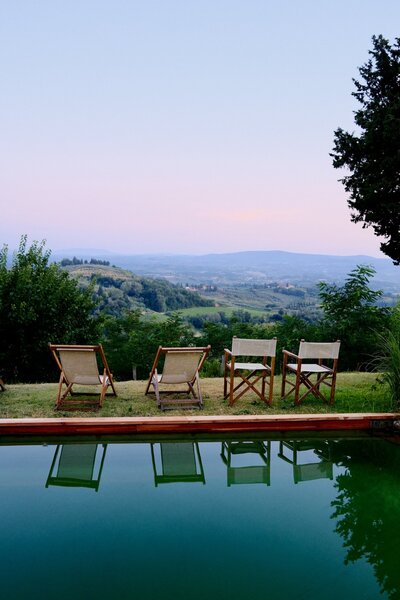 chairs by a pool in tuscany overlooking the countryside