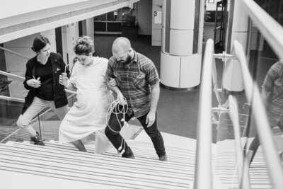 Doula, wife and husband walk stairs at OU Children's to get labor moving.