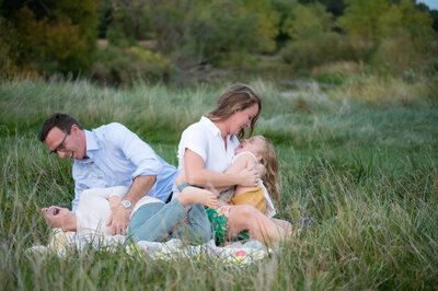 Laughing and snuggling kids and parents near Lake Maxinkuckee during their family portrait session.