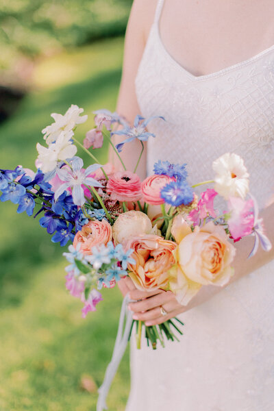 A bride holds a textured, colorful bouquet at Knowlton Mansion.