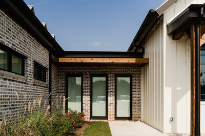 brick and board and batten exterior with black metal and wood accents