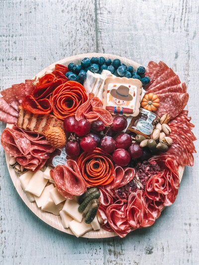 (Serves 8+)  - Assortment of Cured Meats  - Assortment of Soft and Hard Cheese - Fresh seasonal fruit - Sweets - Salty  - Honey jar (1 oz) and/or Jam jar - 1 Shareable box of bread/crackers