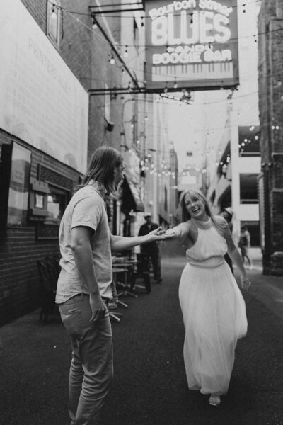 Man and woman dance in the street near Blue's Boogie Bar in Nashville