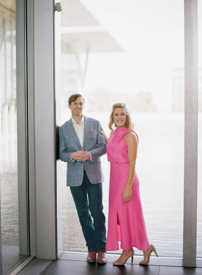 A engagement session photo fo a couple posing beside each other smiling for the camera at an arts museum in forth wroth texas
