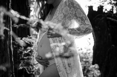 woman holding her belly wearing lace robe