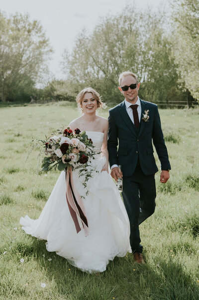 Bride and groom with large pink and maroon bouquet