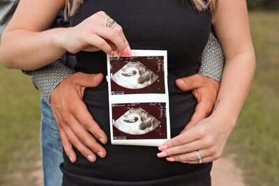 alexis and noah hold ultrasound photos forMaternity Photoshoot