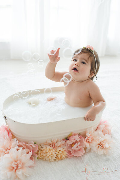 baby girl with bubbles and pink flowers