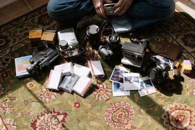 polaroids, film,camera, and super 8 film spread out on a carpet