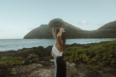 Jenna lifting hat looking out at the water