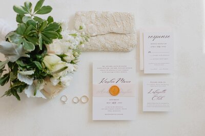 wedding invitation flatlay with wedding rings