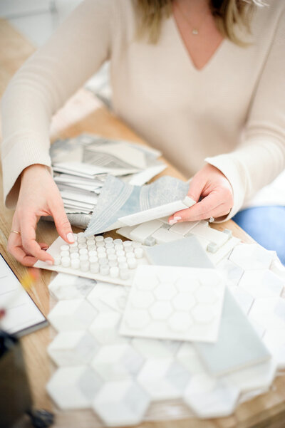 woman picking marble tile and fabric samples for interior design clients