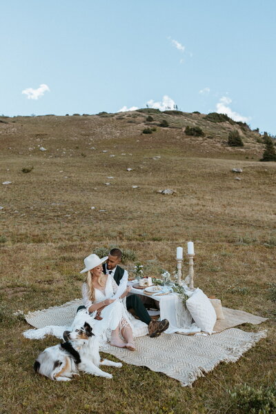 Couple smiling at a boho custom picnic in CO