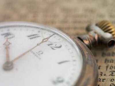 close up picture of an old stop watch laying on newspaper