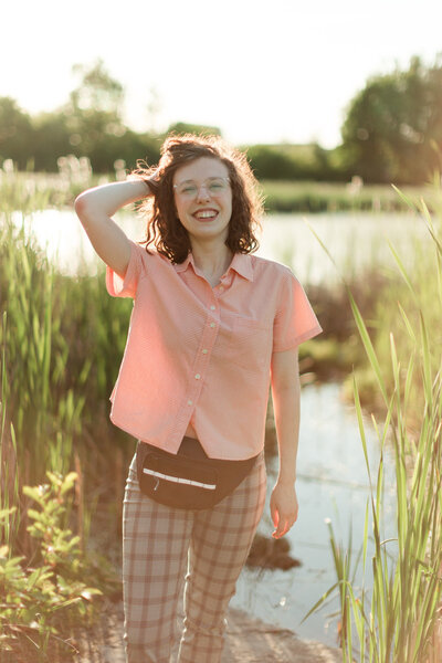 Step into a sun-kissed enchantment with Maria's portrait, captured in the picturesque Dominion Arboretum in Ottawa. Dressed in a chic white and pink plaid shirt, Maria exudes effortless style. The sun's gentle backlight frames her as she gracefully runs her hand through her hair, creating a portrait of radiant serenity amidst nature's beauty.