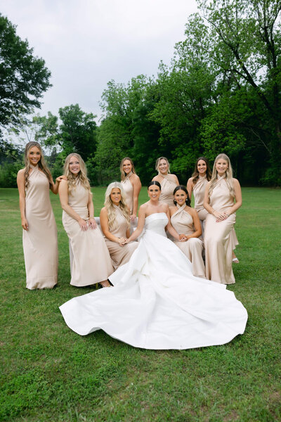 A wedding day photo fo the bride in her white dress surrounded by her bridesmaids