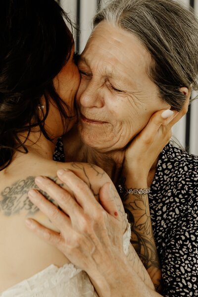 A bride tightly hugs her emotional grandmother.