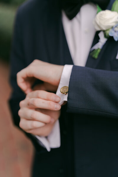 Groom adjusting cufflinks before a luxury estate wedding in North Carolina, styled by a professional wedding planner for an elegant and refined celebration. Rosehill Estates. 