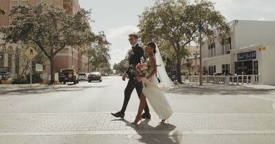bride and groom in shades cross street