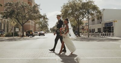 bride and groom in shades cross street