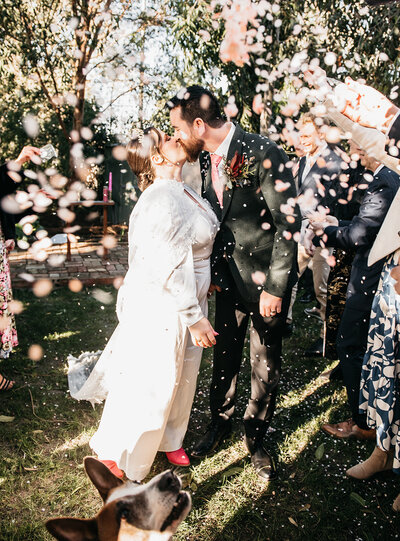Couple exit with confetti toss Melbourne backyard wedding