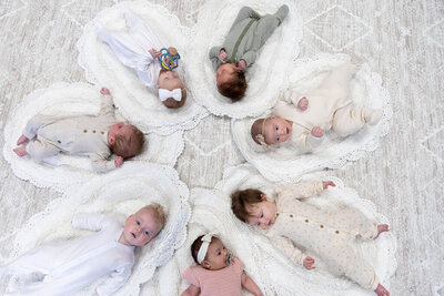 Group of babies arranged in a circle on the floor