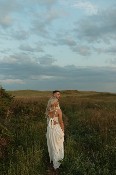 bride and groom walking in field in pei