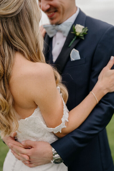 Bride and groom embracing in wedding attire close-up