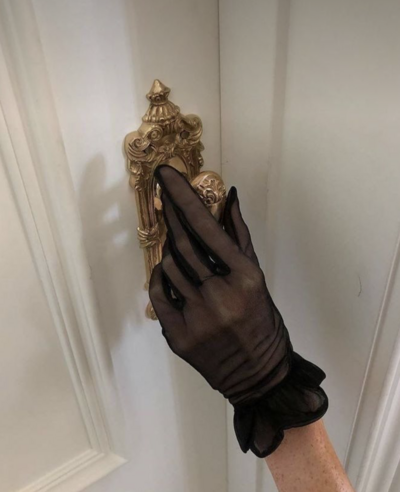 woman wearing gloves knocking on door
