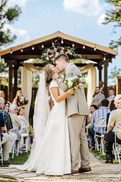 bride and groom kissing after wedding ceremony at the Carriage Place Event Wedding Venue